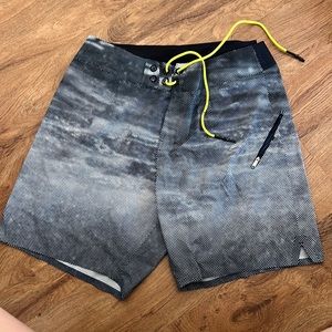 Lululemon men’s swim suit. It is a navy and white pattern with neon green string